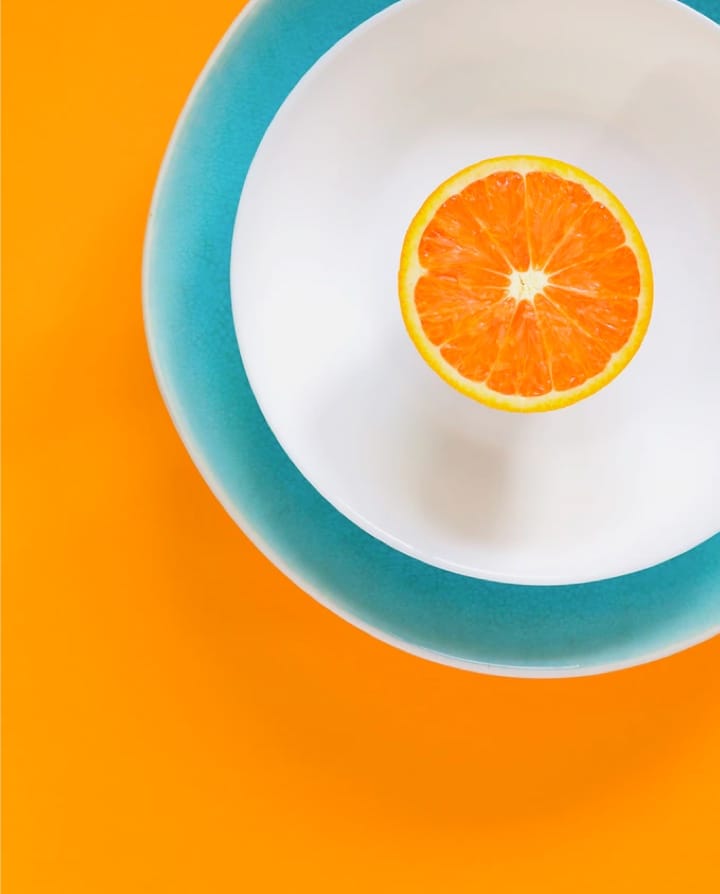 An orange on a white plate